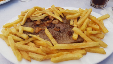 a sandwich sitting on top of a pile of fries