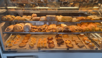 a glass display case filled with different kinds of donuts