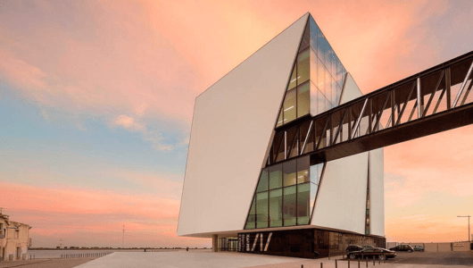 a large building with a sunset in the background