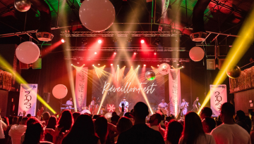 a group of people standing on a stage in front of a crowd